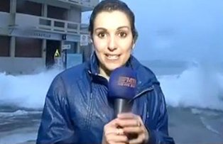 VIDEO / Reporterita, luata pe sus de un val in timp ce transmitea in direct