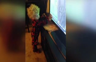 VIDEO / O sa razi. Cum se chinuie un copil sa "opreasca" banda de stiri de pe ecranul televizorului